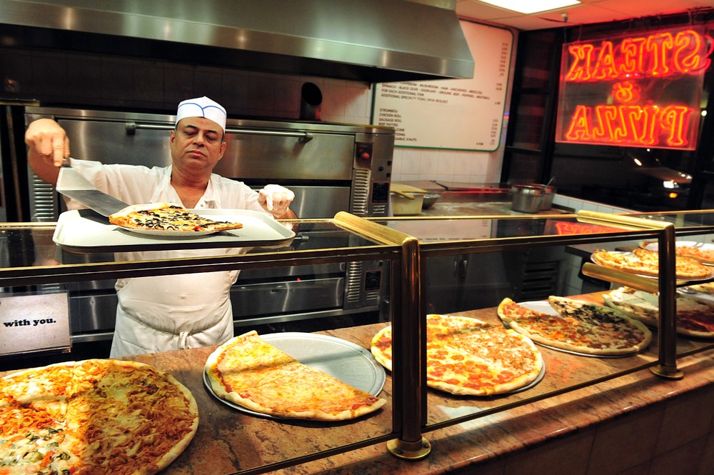 NEW YORK CITY - OCT 11 2009:Pizza chef preparing NYC Pizza Pizzeria restaurant in Manhattan New York. About 5,000,000 pounds of Pizza is consumed in the Untied States alone in one day.