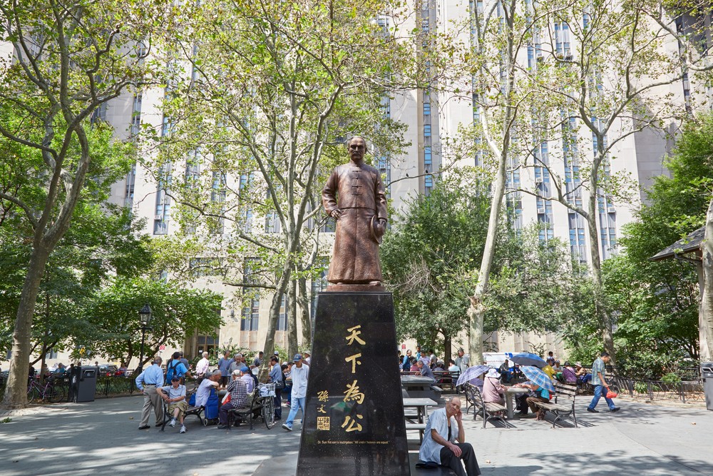 NEW YORK - SEPTEMBER 7: Columbus Park with people playing Chinese Chess and Sen Yat-sen statue on September 7, 2017 in New York. This was the notorious Five Points ghetto during the 19 th century. 