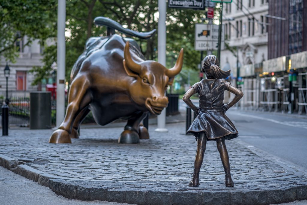 New York, USA - June 25, 2017 - "The Fearless Girl" statue facing Charging Bull in Lower Manhattan, New York City