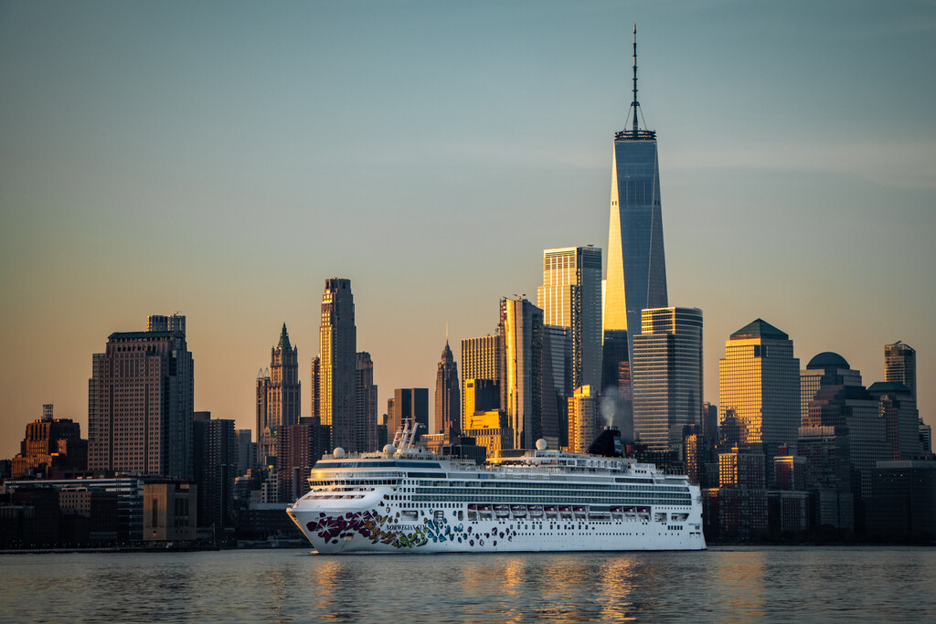 New York, NY USA 04-14-2018: Norwegian Cruise Line ship passing the new World Trade Center in lower Manhattan on an early spring morning