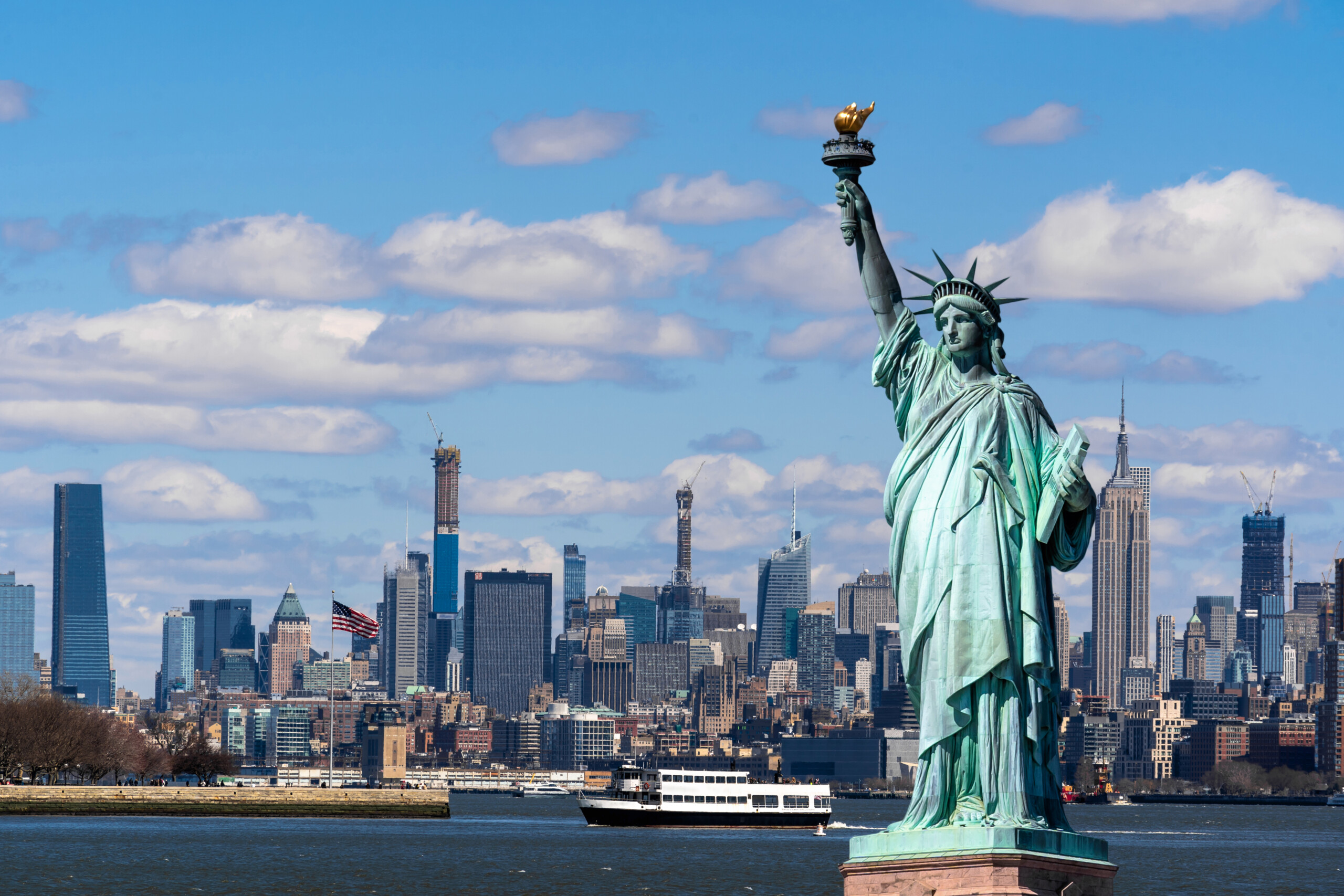 Statua Wolności nad sceną z Nowego Jorku, która znajduje się po stronie rzeki, w dolnym Manhattanie, licencja: shutterstock/By TZIDO SUN