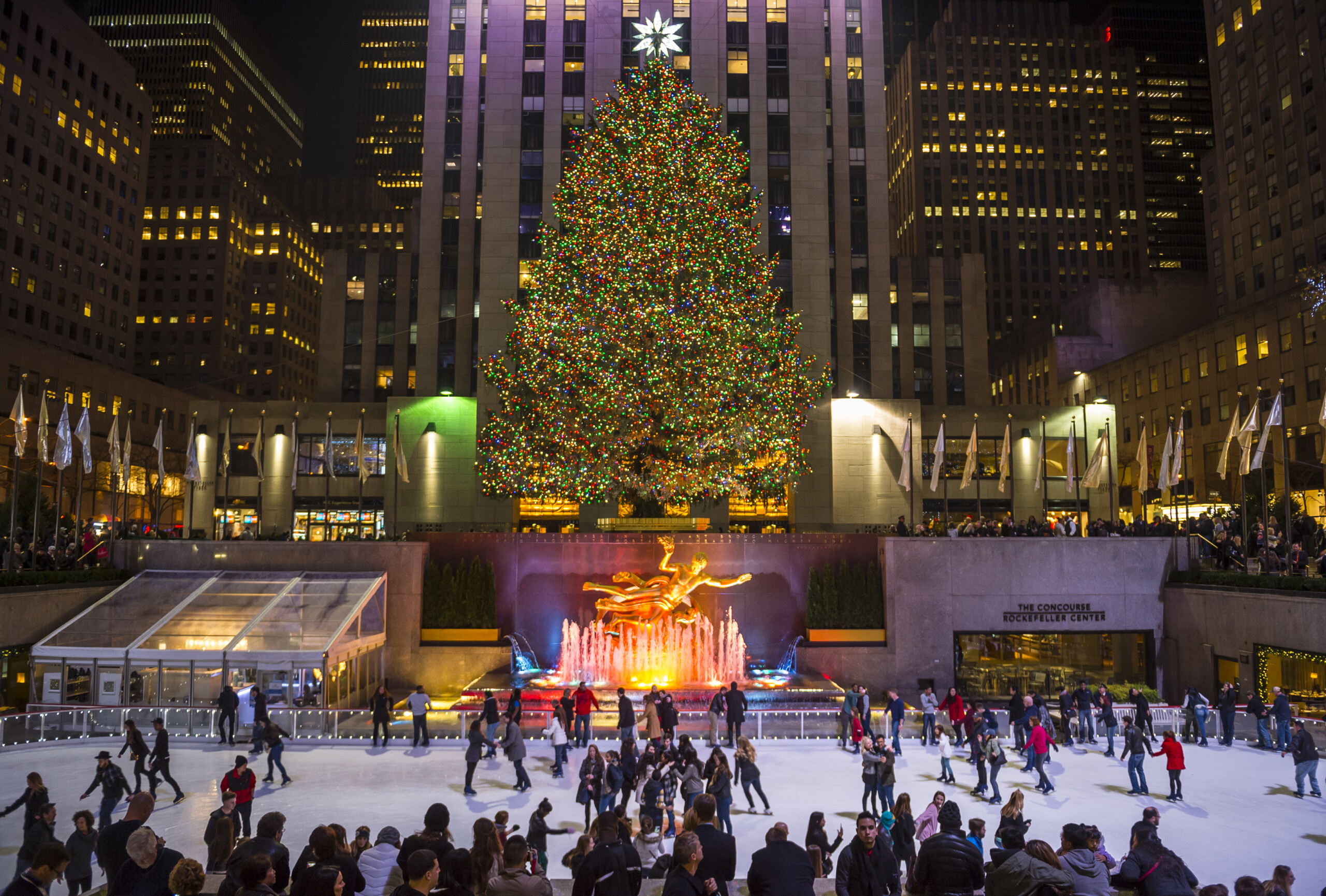 NEW YORK CITY - 10 grudnia 2015: Łyżwiarze wypełniają lodowisko pod choinką Rockefeller Center, licencja: shutterstock/By